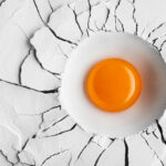 A photo of an egg in flour, creating a crater-like indentation - photography competition submission